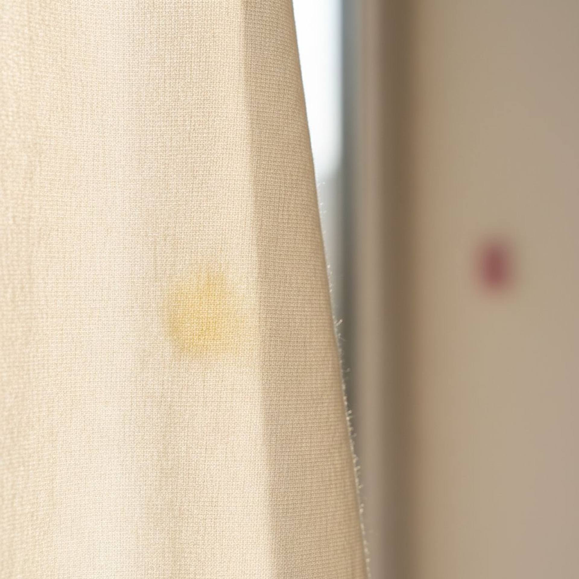 Fabric backlit shows the invisible yellow stain not visible after washing